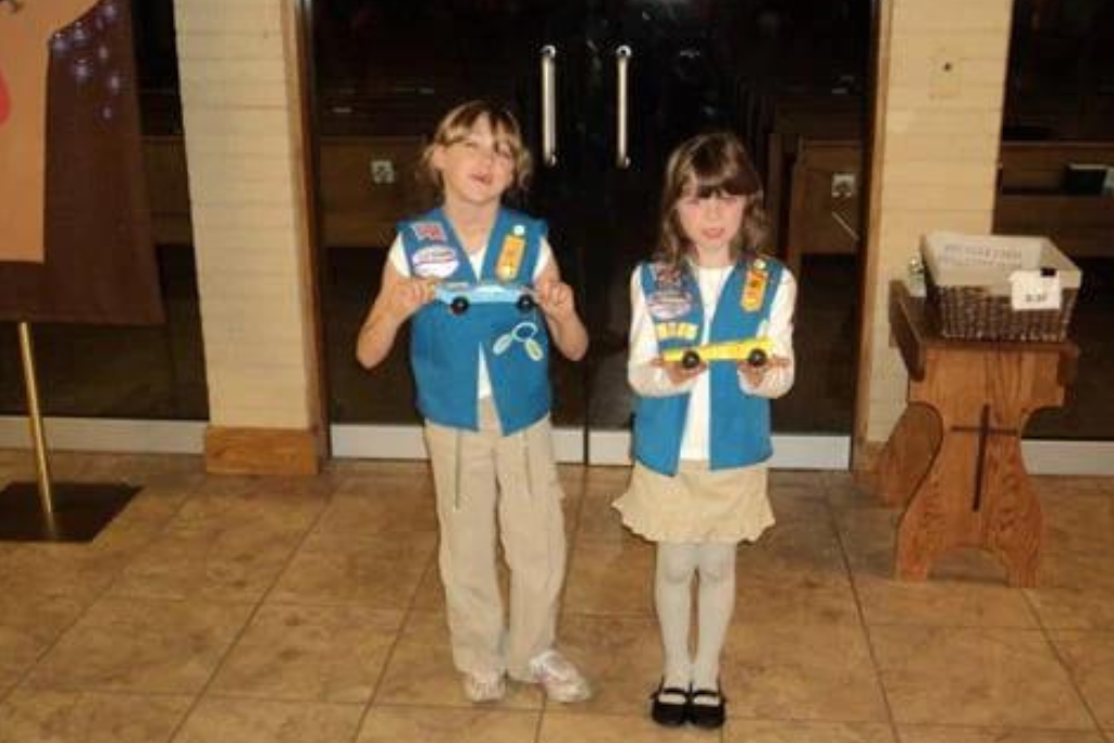 girls holding derby cars